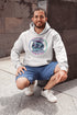 Featuring a stunning graphic of a majestic snowy owl in flight, set against the glowing northern lights, this hoodie embodies the freedom and grace of the province’s untamed wilderness.